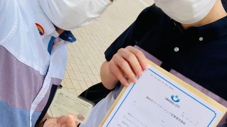 受領証を手にする2人